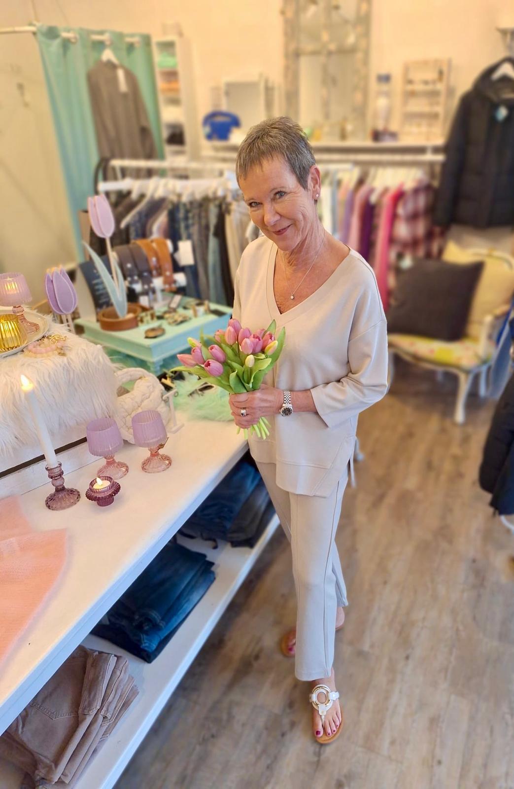 Judith Selle in der Boutique Blickfang mit einem Strauß Tulpen